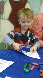Thomas, 4, concentrates on cutting out at Storytime