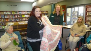Tabitha from Housing Plus is presented with rugs by Tudi on behalf of Orange Purlers