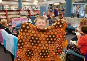 Youngest knitter Bailey with a rug he is sewing together