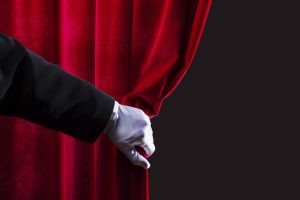 Close up of hand in white glove open the curtain. Place for text